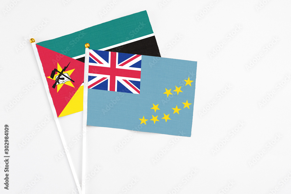 Tuvalu and Mozambique stick flags on white background. High quality fabric, miniature national flag. Peaceful global concept.White floor for copy space. Tuvalu and Mozambique stick flags on white background. High quality fabric, miniature national flag. Peaceful global concept.White floor for copy space.