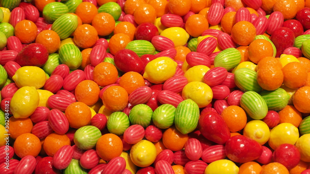 Close up of bowls filled with a large selection of different colored soft candies. Green, Orange, Red and yellow candies