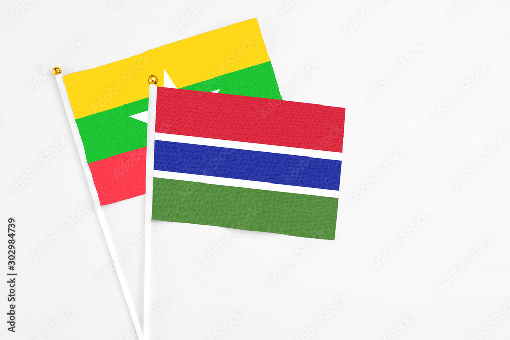 Obraz premium Gambia and Myanmar stick flags on white background. High quality fabric, miniature national flag. Peaceful global concept.White floor for copy space.