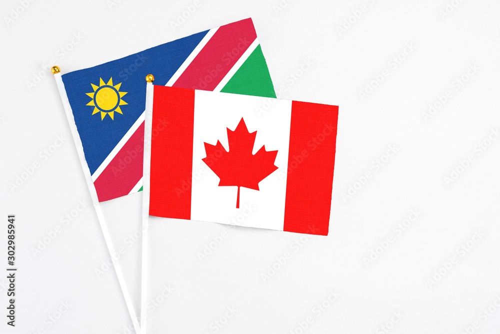 Canada and Namibia stick flags on white background. High quality fabric, miniature national flag. Peaceful global concept.White floor for copy space.