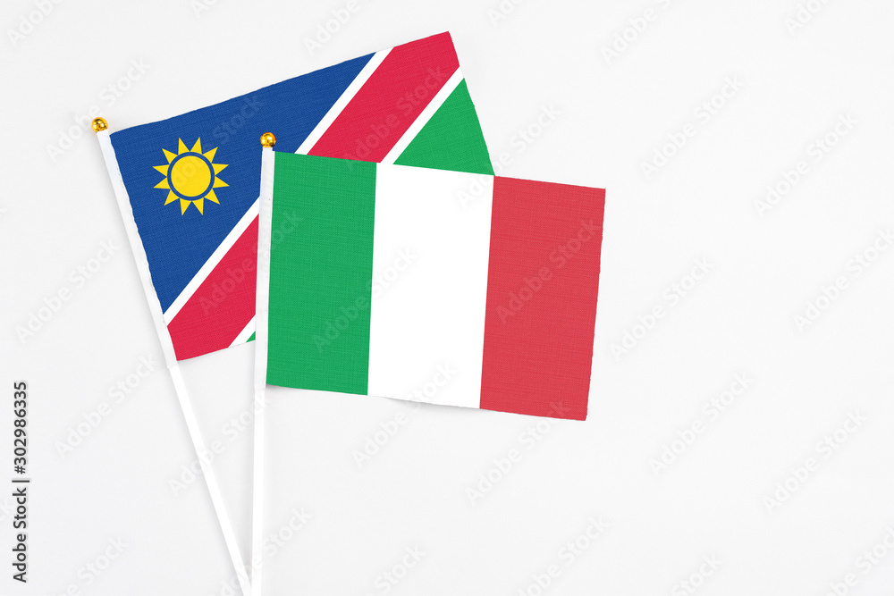 Italy and Namibia stick flags on white background. High quality fabric, miniature national flag. Peaceful global concept.White floor for copy space. Italy and Namibia stick flags on white background. High quality fabric, miniature national flag. Peaceful global concept.White floor for copy space.