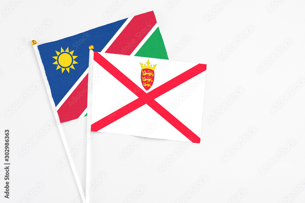 Jersey and Namibia stick flags on white background. High quality fabric, miniature national flag. Peaceful global concept.White floor for copy space. Jersey and Namibia stick flags on white background. High quality fabric, miniature national flag. Peaceful global concept.White floor for copy space.