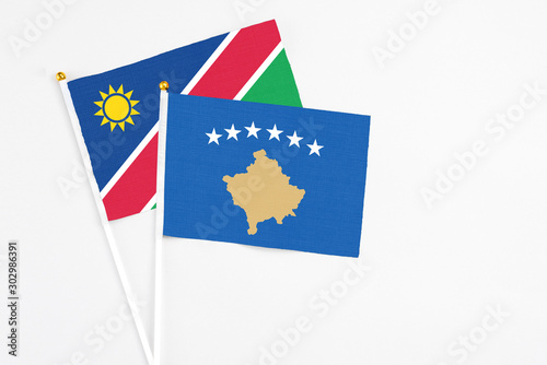 Kosovo and Namibia stick flags on white background. High quality fabric  miniature national flag. Peaceful global concept.White floor for copy space.