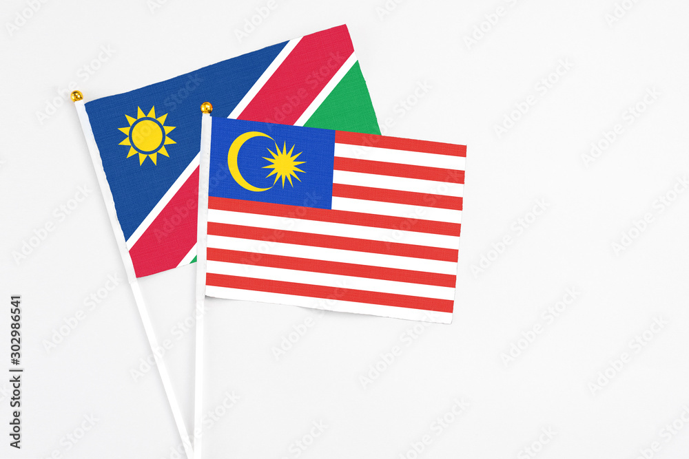 Malaysia and Namibia stick flags on white background. High quality fabric, miniature national flag. Peaceful global concept.White floor for copy space. Malaysia and Namibia stick flags on white background. High quality fabric, miniature national flag. Peaceful global concept.White floor for copy space.