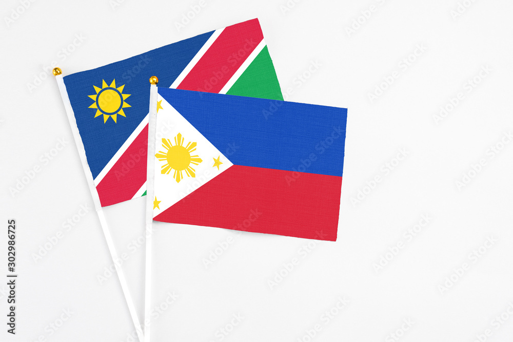 Philippines and Namibia stick flags on white background. High quality fabric, miniature national flag. Peaceful global concept.White floor for copy space. Philippines and Namibia stick flags on white background. High quality fabric, miniature national flag. Peaceful global concept.White floor for copy space.