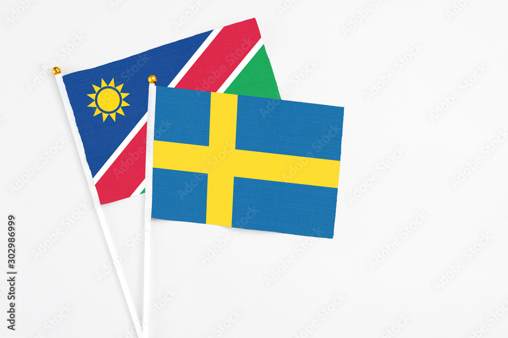 Sweden and Namibia stick flags on white background. High quality fabric, miniature national flag. Peaceful global concept.White floor for copy space.