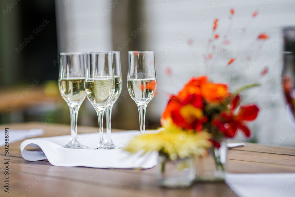 Wine glasses ready for a catering service and a bouquet of flowers. Wine glasses ready for a catering service and a bouquet of flowers.