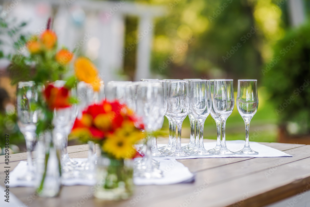 Wine glasses ready for a catering service and a bouquet of flowers.