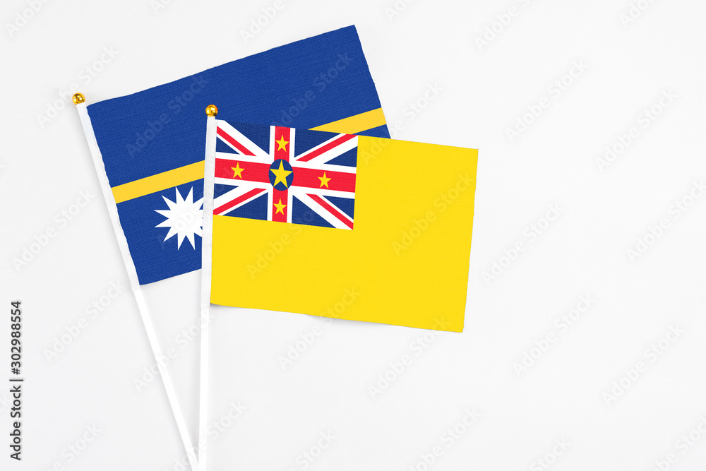Niue and Nauru stick flags on white background. High quality fabric, miniature national flag. Peaceful global concept.White floor for copy space. Niue and Nauru stick flags on white background. High quality fabric, miniature national flag. Peaceful global concept.White floor for copy space.