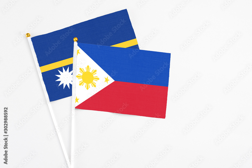 Philippines and Nauru stick flags on white background. High quality fabric, miniature national flag. Peaceful global concept.White floor for copy space. Philippines and Nauru stick flags on white background. High quality fabric, miniature national flag. Peaceful global concept.White floor for copy space.
