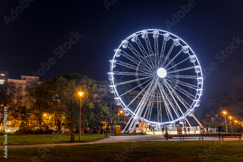 Huge Christmas illuminated wheel for people with a beautiful view of Moravian Square in Brno moving during a cold evening during the time lapse video dominates the Christmas preparations in city