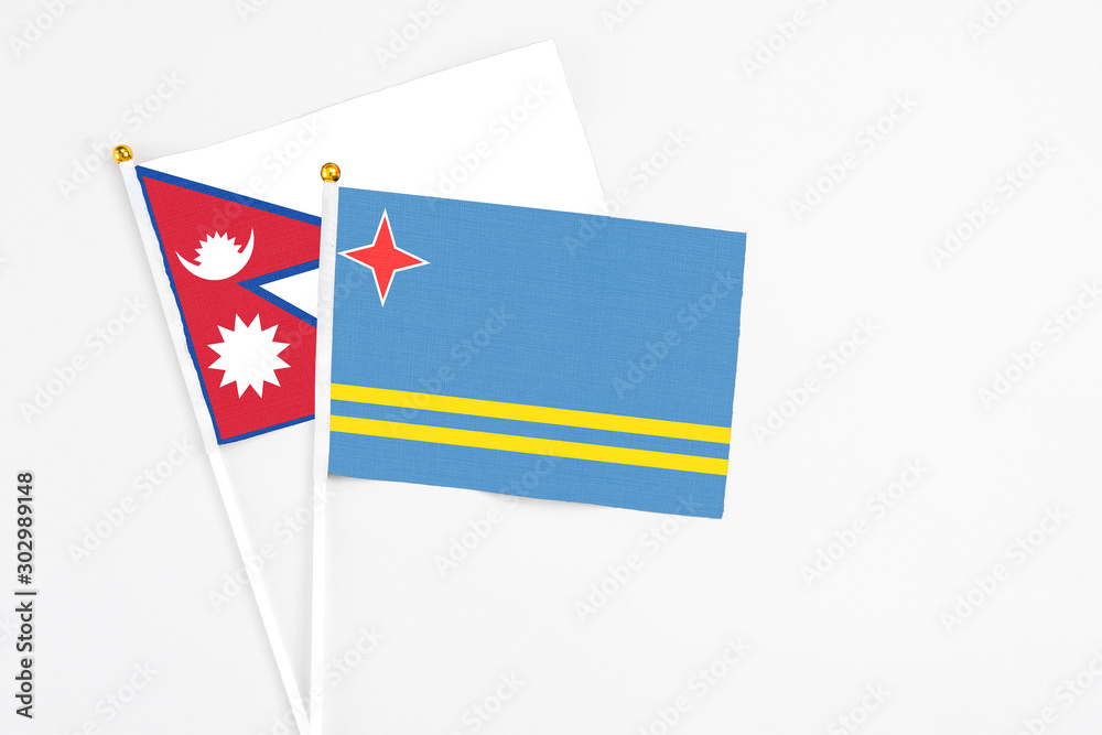 Aruba and Nepal stick flags on white background. High quality fabric, miniature national flag. Peaceful global concept.White floor for copy space. Aruba and Nepal stick flags on white background. High quality fabric, miniature national flag. Peaceful global concept.White floor for copy space.