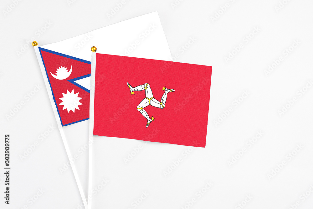 Isle Of Man and Nepal stick flags on white background. High quality fabric, miniature national flag. Peaceful global concept.White floor for copy space.