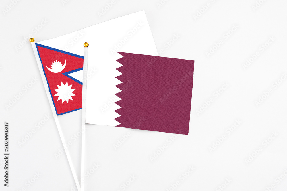 Qatar and Nepal stick flags on white background. High quality fabric, miniature national flag. Peaceful global concept.White floor for copy space. Qatar and Nepal stick flags on white background. High quality fabric, miniature national flag. Peaceful global concept.White floor for copy space.