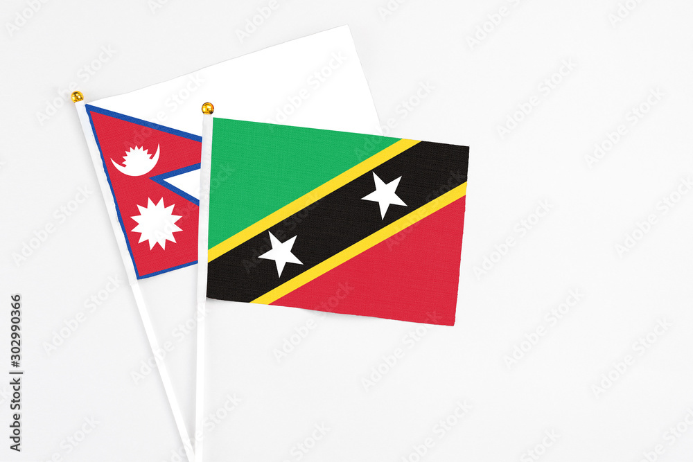Saint Kitts And Nevis and Nepal stick flags on white background. High quality fabric, miniature national flag. Peaceful global concept.White floor for copy space. Saint Kitts And Nevis and Nepal stick flags on white background. High quality fabric, miniature national flag. Peaceful global concept.White floor for copy space.