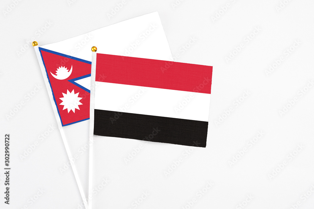 Yemen and Nepal stick flags on white background. High quality fabric, miniature national flag. Peaceful global concept.White floor for copy space. Yemen and Nepal stick flags on white background. High quality fabric, miniature national flag. Peaceful global concept.White floor for copy space.