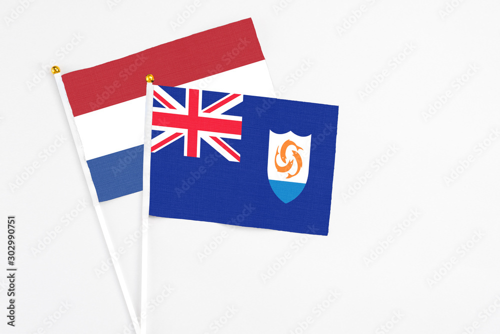 Fototapeta premium Anguilla and Netherlands stick flags on white background. High quality fabric, miniature national flag. Peaceful global concept.White floor for copy space.
