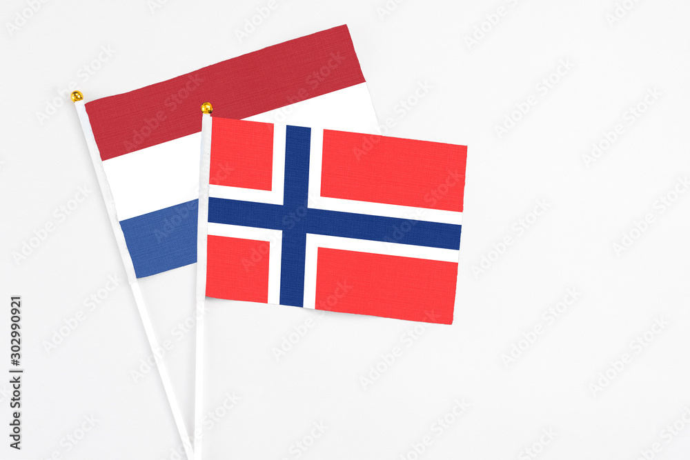 Bouvet Islands and Netherlands stick flags on white background. High quality fabric, miniature national flag. Peaceful global concept.White floor for copy space.