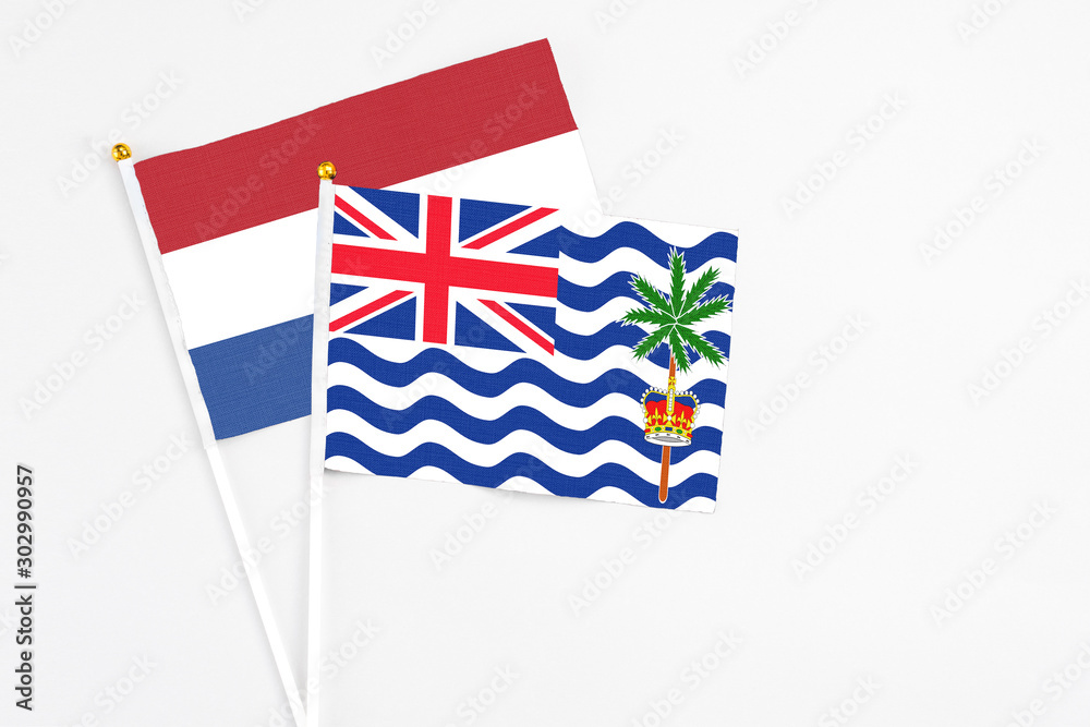 Fototapeta premium British Indian Ocean Territory and Netherlands stick flags on white background. High quality fabric, miniature national flag. Peaceful global concept.White floor for copy space.