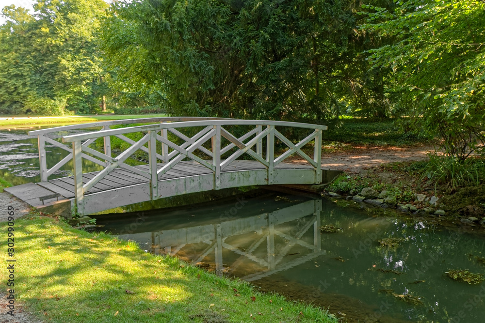 Small wooden bridge over a stream with trees in the background. Small wooden bridge over a stream with trees in the background.
