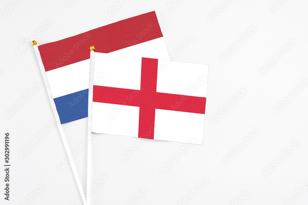 England and Netherlands stick flags on white background. High quality fabric, miniature national flag. Peaceful global concept.White floor for copy space.