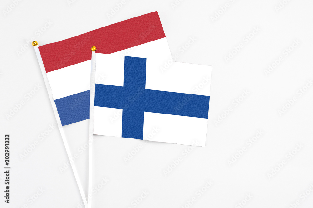 Finland and Netherlands stick flags on white background. High quality fabric, miniature national flag. Peaceful global concept.White floor for copy space.