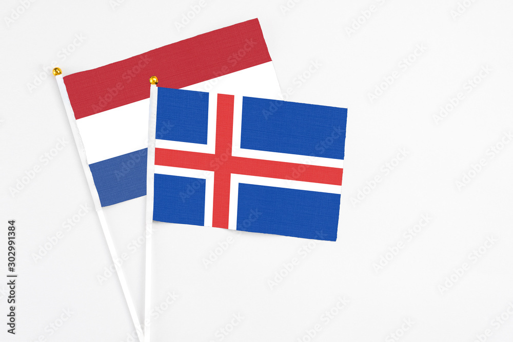 Iceland and Netherlands stick flags on white background. High quality fabric, miniature national flag. Peaceful global concept.White floor for copy space.