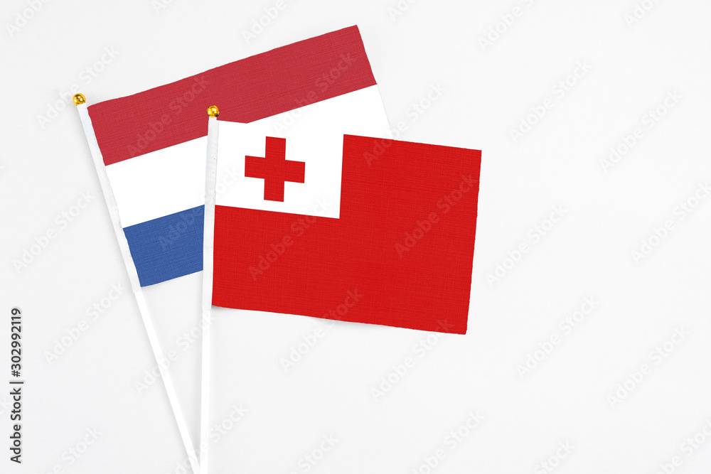 Tonga and Netherlands stick flags on white background. High quality fabric, miniature national flag. Peaceful global concept.White floor for copy space.