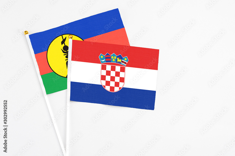 Naklejka premium Croatia and New Caledonia stick flags on white background. High quality fabric, miniature national flag. Peaceful global concept.White floor for copy space.