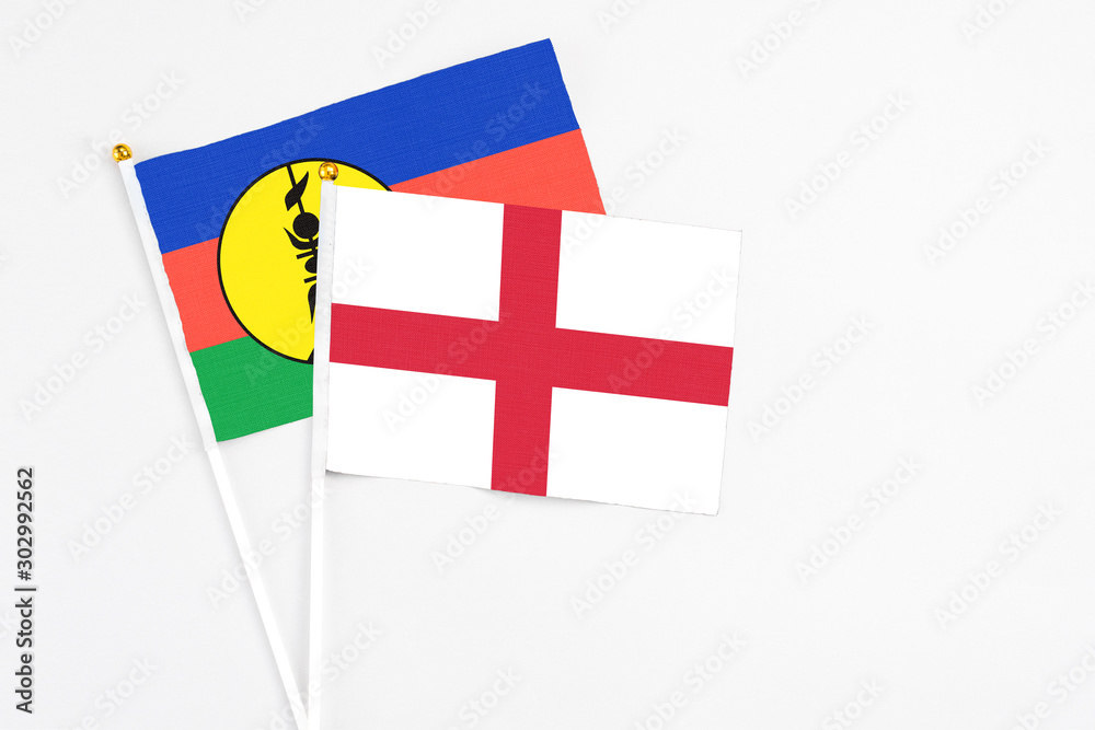 England and New Caledonia stick flags on white background. High quality fabric, miniature national flag. Peaceful global concept.White floor for copy space. England and New Caledonia stick flags on white background. High quality fabric, miniature national flag. Peaceful global concept.White floor for copy space.