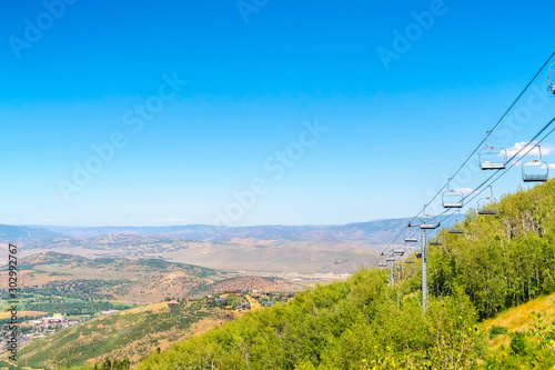 Park City during off season with chairlifts over green trees and mountain view