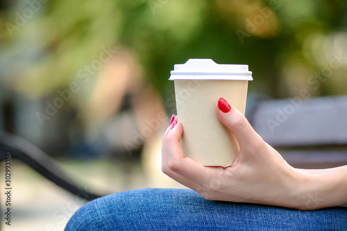 girl holds a cup of coffee. girl holds a disposable cup. cappuccino, latte. take-away coffee concept, coffee to go. photo