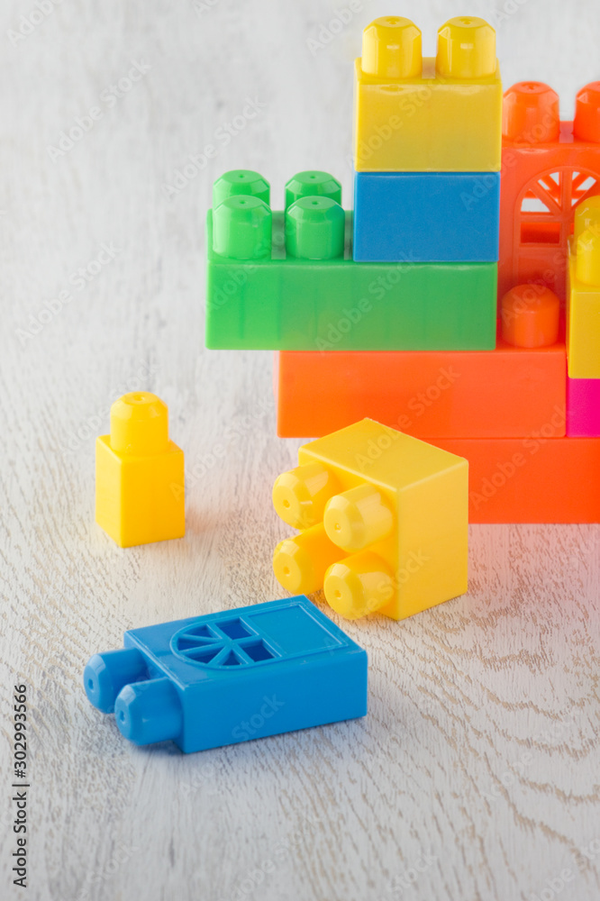 construction of parts of a children's designer of different shapes and different colors on a wooden tabletop construction of parts of a children's designer of different shapes and different colors on a wooden tabletop