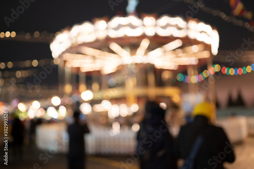Carousel with burning lights , blurred photo.