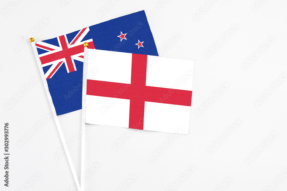 England and New Zealand stick flags on white background. High quality fabric, miniature national flag. Peaceful global concept.White floor for copy space.
