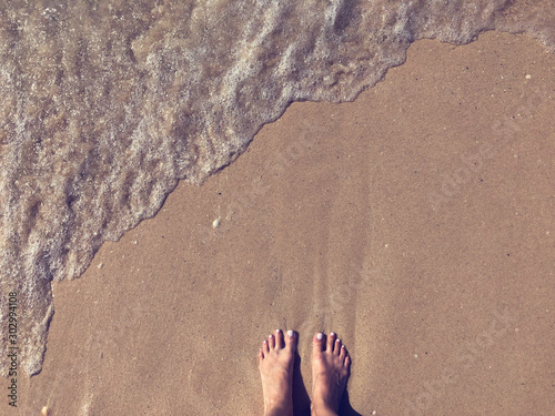 Woman legs on sand beach.