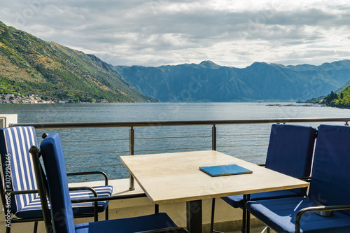 Sunny view of Boka Kotor bay from coastal cafe near Perast, Montenegro.