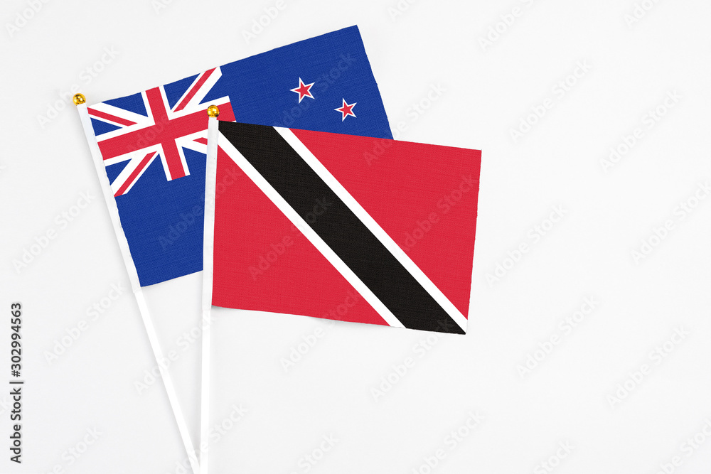 Trinidad And Tobago and New Zealand stick flags on white background. High quality fabric, miniature national flag. Peaceful global concept.White floor for copy space. Trinidad And Tobago and New Zealand stick flags on white background. High quality fabric, miniature national flag. Peaceful global concept.White floor for copy space.