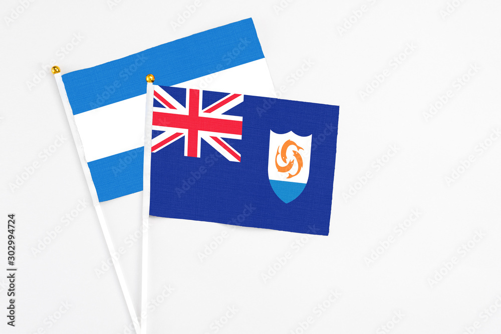 Fototapeta premium Anguilla and Nicaragua stick flags on white background. High quality fabric, miniature national flag. Peaceful global concept.White floor for copy space.