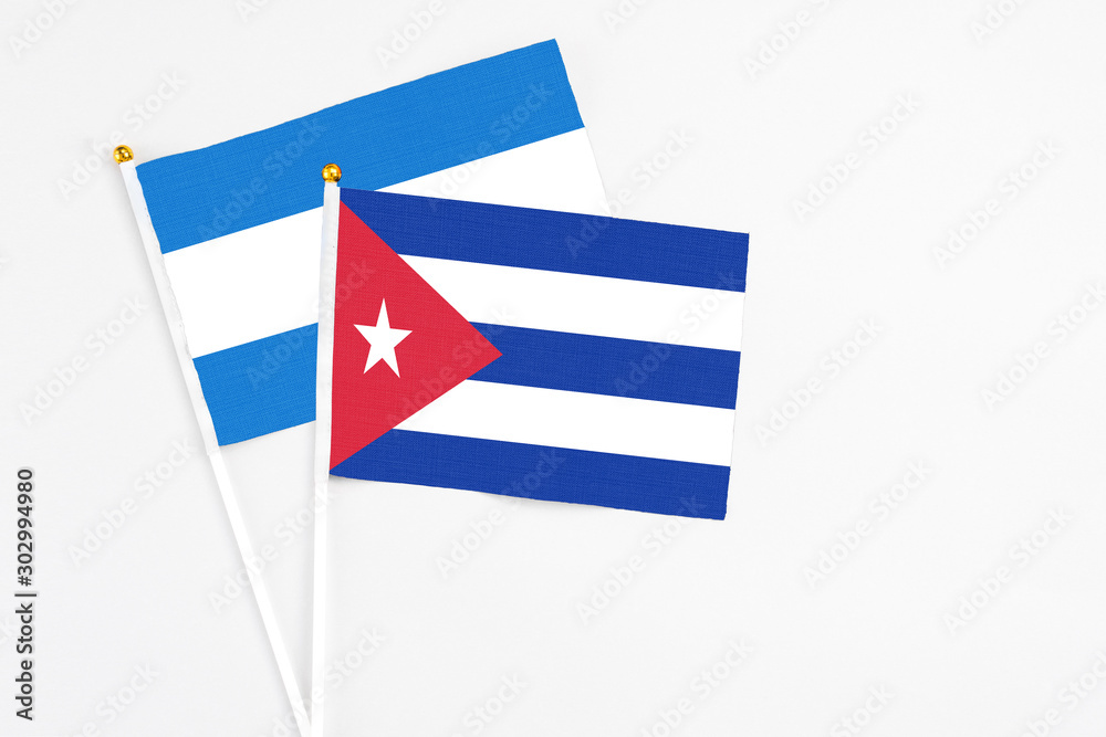 Cuba and Nicaragua stick flags on white background. High quality fabric, miniature national flag. Peaceful global concept.White floor for copy space. Cuba and Nicaragua stick flags on white background. High quality fabric, miniature national flag. Peaceful global concept.White floor for copy space.