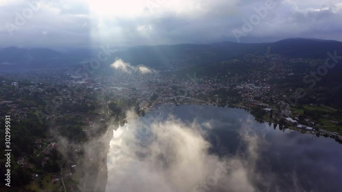 Flight through the clouds over Lac de Gérardmer on a partly cloudy morning. photo