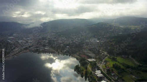 Panning aerial shot of a lake reflecting the low hanging clouds on a partly cloudy morning. photo