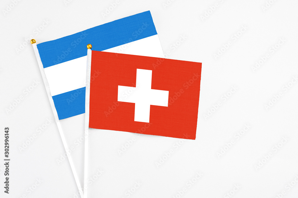 Switzerland and Nicaragua stick flags on white background. High quality fabric, miniature national flag. Peaceful global concept.White floor for copy space.