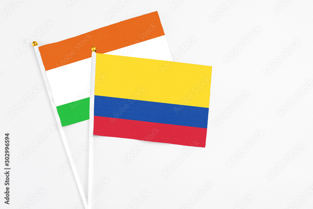 Colombia and Niger stick flags on white background. High quality fabric, miniature national flag. Peaceful global concept.White floor for copy space. Colombia and Niger stick flags on white background. High quality fabric, miniature national flag. Peaceful global concept.White floor for copy space.