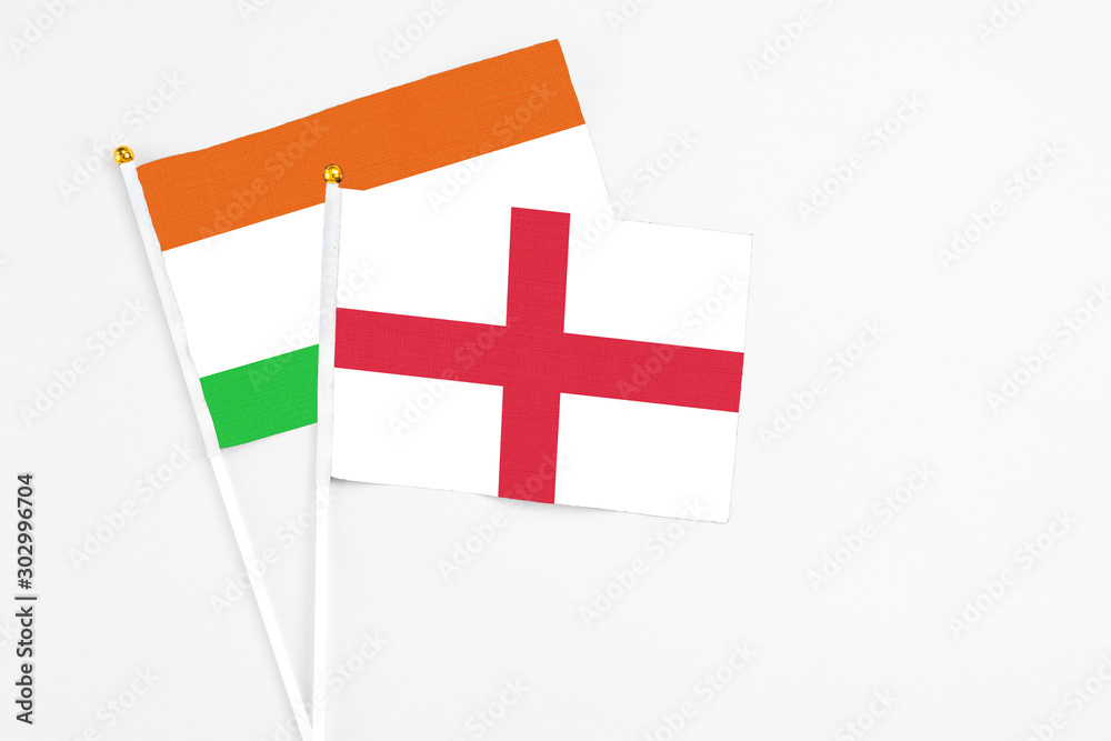 England and Niger stick flags on white background. High quality fabric, miniature national flag. Peaceful global concept.White floor for copy space.
