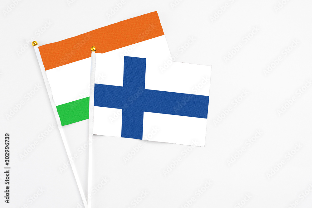 Finland and Niger stick flags on white background. High quality fabric, miniature national flag. Peaceful global concept.White floor for copy space.