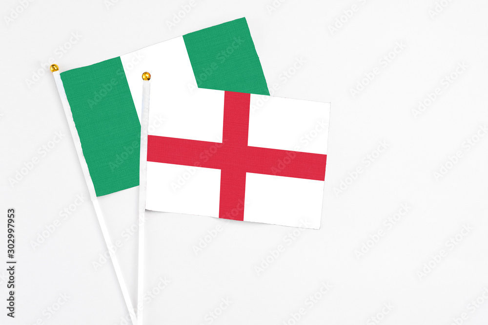England and Nigeria stick flags on white background. High quality fabric, miniature national flag. Peaceful global concept.White floor for copy space.