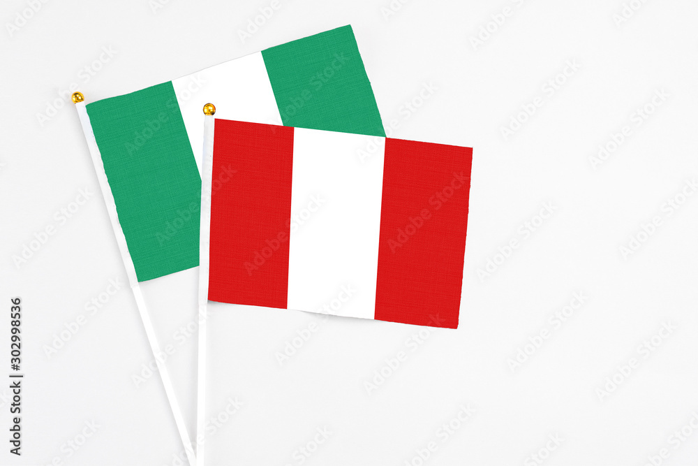 Peru and Nigeria stick flags on white background. High quality fabric, miniature national flag. Peaceful global concept.White floor for copy space. Peru and Nigeria stick flags on white background. High quality fabric, miniature national flag. Peaceful global concept.White floor for copy space.