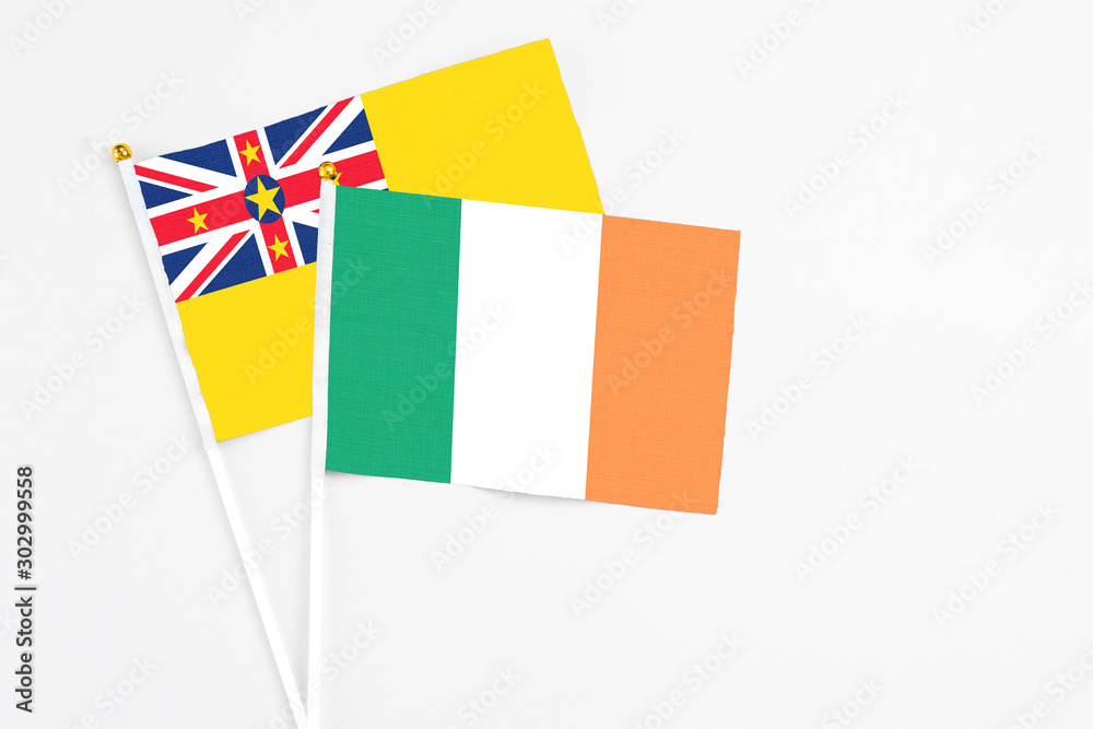 Ireland and Niue stick flags on white background. High quality fabric, miniature national flag. Peaceful global concept.White floor for copy space. Ireland and Niue stick flags on white background. High quality fabric, miniature national flag. Peaceful global concept.White floor for copy space.