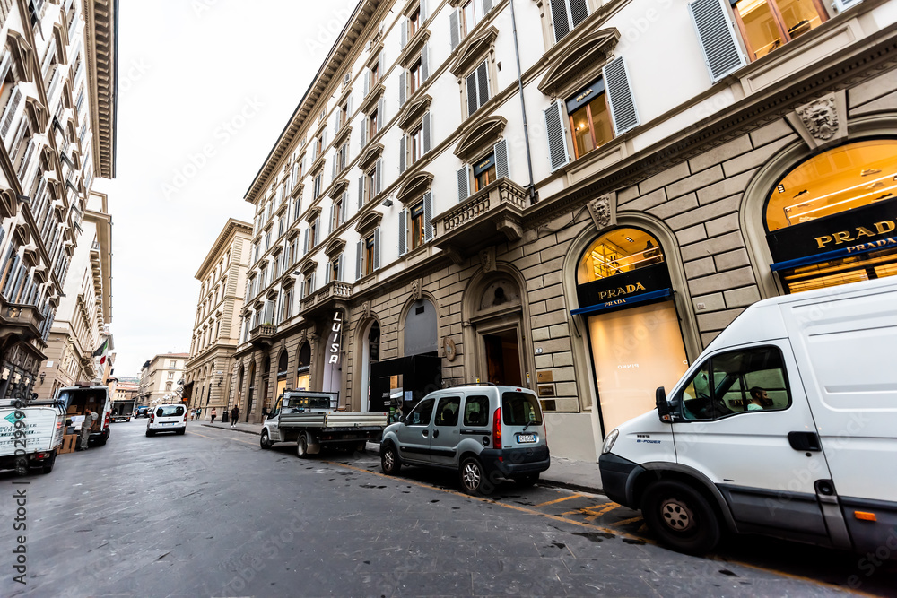 Firenze, Italy - August 31, 2018: Outside exterior of Prada stores  buildings in Tuscany on Via Roma alley street in dark morning wide angle  view and cars parked Stock Photo | Adobe Stock